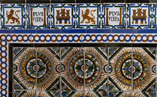 A lion, a castle and mudejar motifs on a tile on the walls of the Alcazar in Seville, Spain