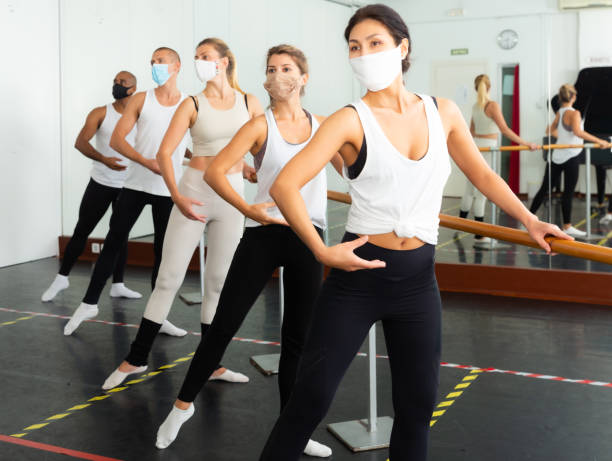 istock People doing exercises on stretching ballet barre during COVID-19 1434978338
