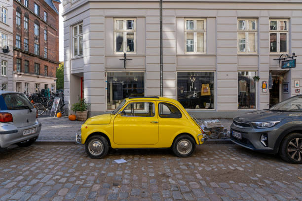 Yellow Vintage Fiat 500 Copenhagen, Denmark - October 18, 2022: A yellow vintage Fiat 500 parked in a street little fiat car stock pictures, royalty-free photos & images