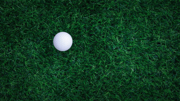 golfball nahaufnahme auf abschlagsgras auf verschwommener wunderschöner landschaft mit golfhintergrund. konzeptieren sie internationalen sport, der auf präzisionsfähigkeiten für die gesundheitliche entspannung angewiesen ist. draufsicht - golf power golf course challenge stock-fotos und bilder