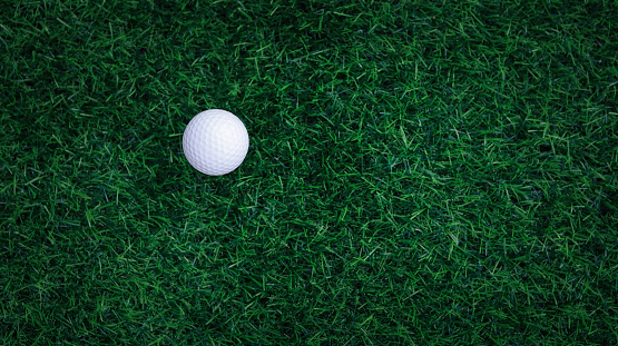 Golf ball close up on tee grass on blurred beautiful landscape of golf background. Concept international sport that rely on precision skills for health relaxation. top view