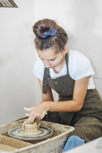 istock Teenage girl creates pottery in pottery workshop. Creative process. Hobby and learning concept 1434987132