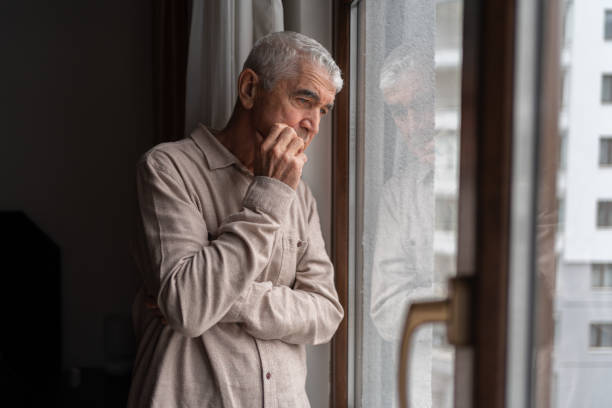 istock Lonely Senior Man Looking Through The Window 1434989251