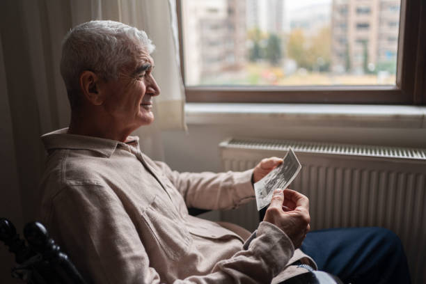 uomo anziano che guarda una vecchia foto - family tree retro revival photograph senior adult foto e immagini stock