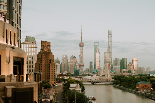 A close shot of the city view of Shanghai China, an urban skyline including many skyscrapers or tall commercial or financial buildings, tower, shopping malls, apartment buildings and other architectures, as well as traffic on the road, around the river, showing the lifestyle and culture of a modern developed China city with its view.