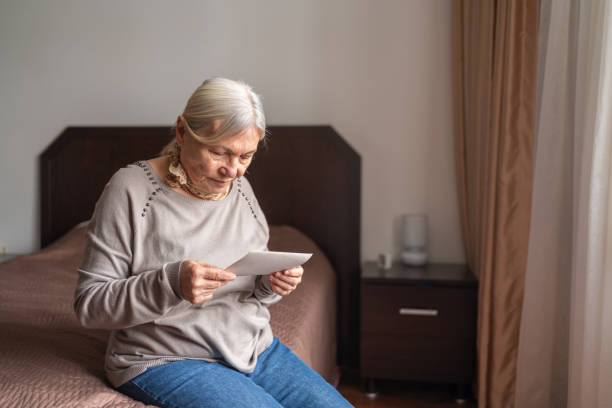 istock Senior Woman Looking At An Old Photo 1434992010