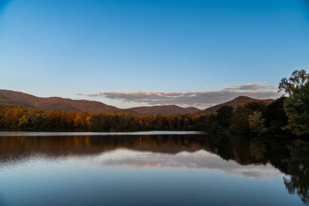 istock Large lake reflecting mountains covered with dense forest in the evening 1434993801