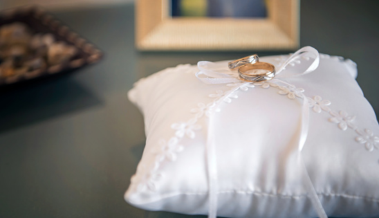 Wedding rings placed on top of a white pillow.