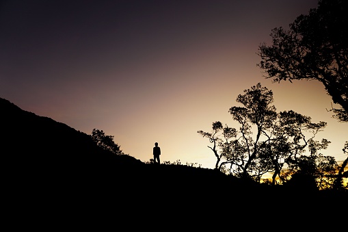 A silhouette of a boy kid near the Tanralili Lake at sunset in Sulawesi, Indonesia