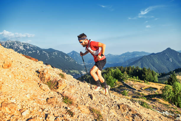 istock Man climbs a rocky slope with poles 1435000183