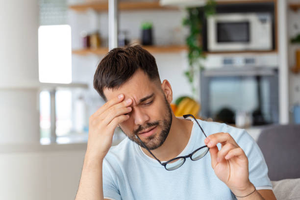 istock Man with tired eyes after long work holding his eyeglasses 1435001618