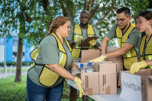 istock Volunteers arranging donation boxes on table at a public park 1435002011