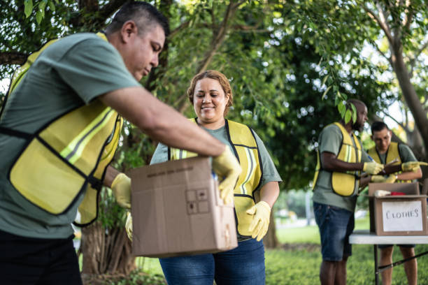 istock Volunteers carrying cardboard box at a public park 1435002012