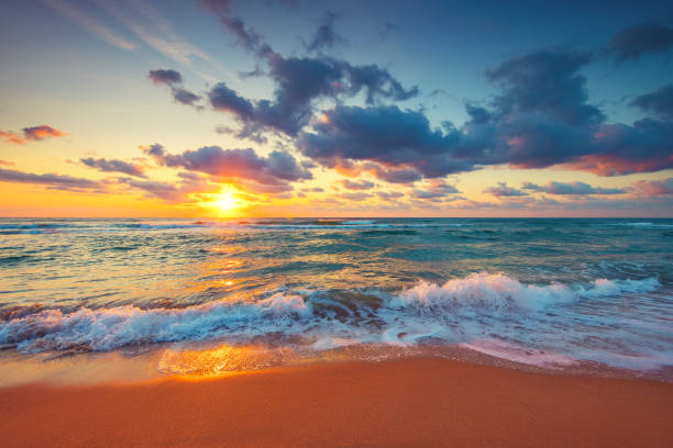 belo nascer do sol sobre as ondas do mar e praia na praia da ilha tropical - marquesas islands - fotografias e filmes do acervo