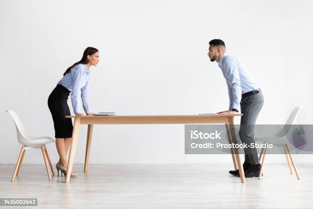Businessman And Businesswoman Staring At Each Other Arguing In Office Stock Photo - Download Image Now