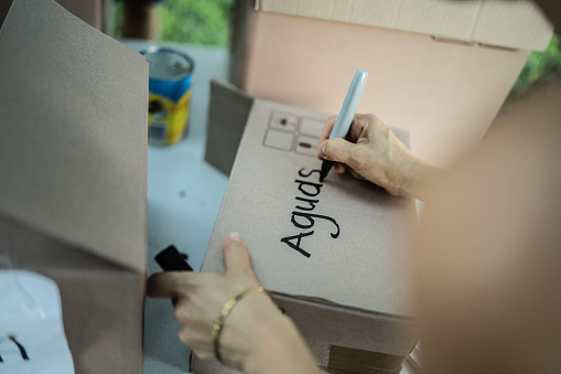 Close-up of a people writing on cardboard box