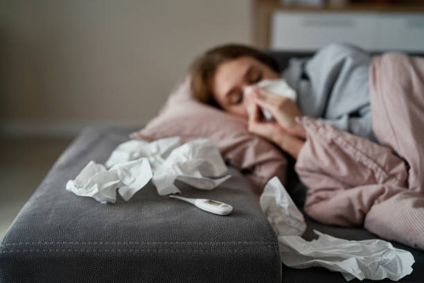 istock Caucasian young woman with high temperature and flu lying down on sofa 1435003593