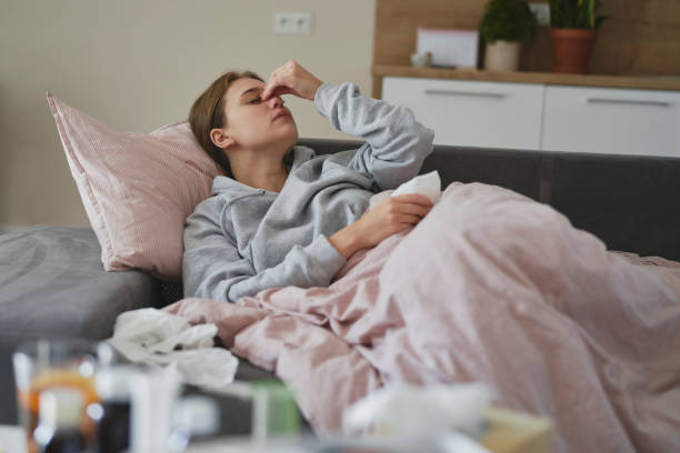 istock Caucasian woman lying on sofa with flu at home 1435003940