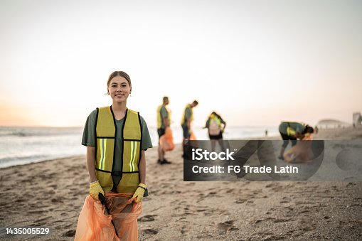 istock Portrait of recycler young woman at beach 1435005529