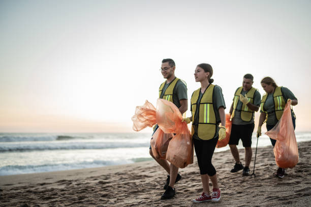 des recycleurs parlent en marchant sur la plage - dépollution photos et images de collection