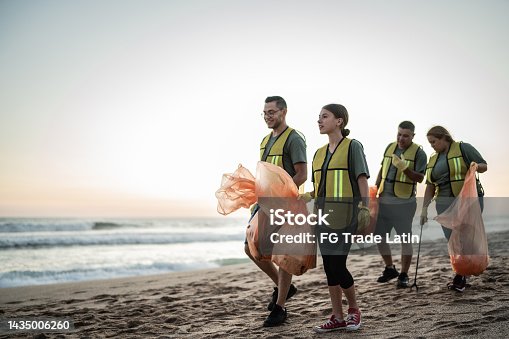 istock Recyclers talking while walking on the beach 1435006260