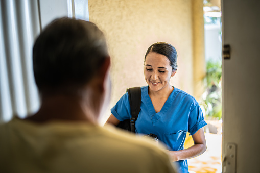 Mid adult nurse arriving at client home