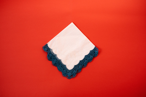 Cotton handkerchiefs with embroidery and crochet blue lace on red Background