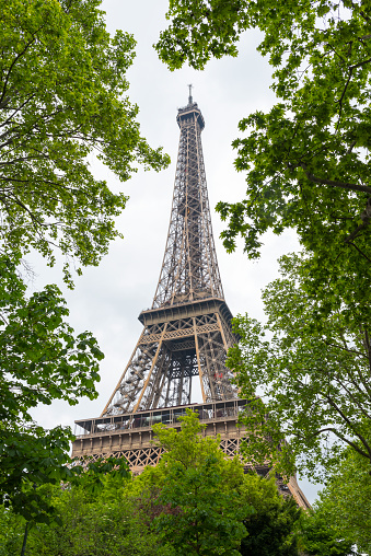 A closeup of the Eiffel Tower on a cloudy day