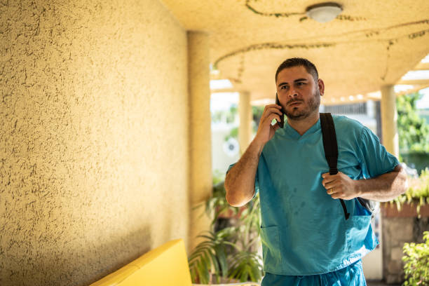 Mid adult nurse coming home using phone