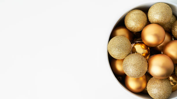 a cone full of golden Christmas balls with white background and space for copying stock photo