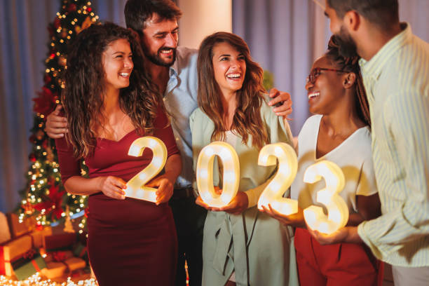 istock Friends holding illuminative numbers 2023 at New Years Eve midnight countdown 1435013321
