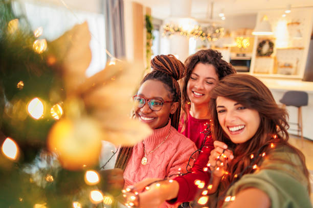istock Girl friends decorating Christmas tree 1435013449