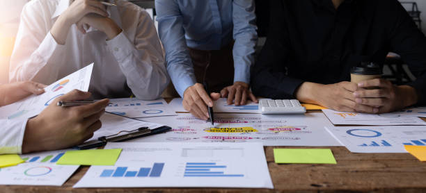 istock Financial analysts analyze business financial reports on a digital tablet planning investment project during a discussion at a meeting of corporate showing the results of their successful teamwork. 1435014528