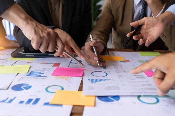 istock Financial analysts analyze business financial reports on a digital tablet planning investment project during a discussion at a meeting of corporate showing the results of their successful teamwork. 1435014543