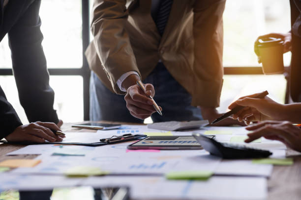 istock Financial analysts analyze business financial reports on a digital tablet planning investment project during a discussion at a meeting of corporate showing the results of their successful teamwork. 1435014557