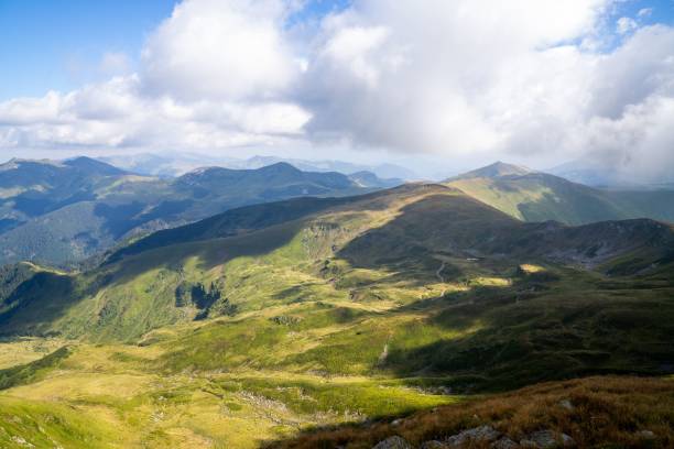 istock View of white clouds and blue sky over layered mountain ranges and valley covered with vegetation 1435015701