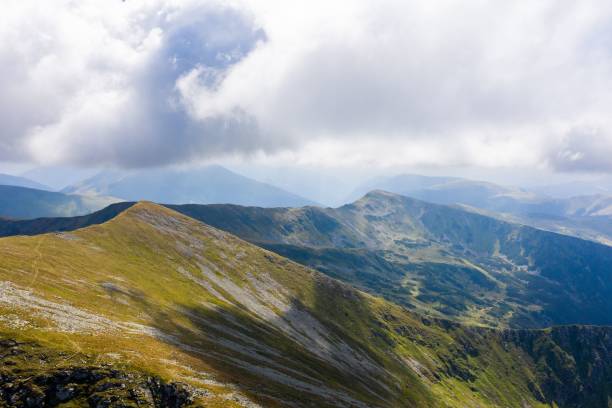 istock View of white clouds and blue sky over layered mountain ranges and valley covered with vegetation 1435015916