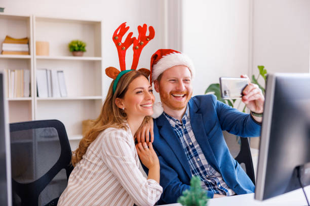 istock Business people taking selfies while celebrating Christmas at the office 1435019522