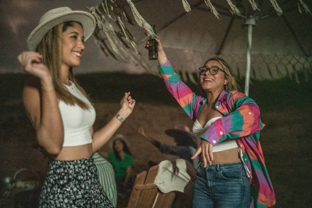 istock Female friends dancing and having fun on the beach 1435020571