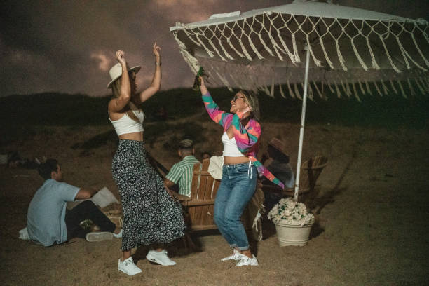 istock Female friends dancing and having fun on the beach 1435020573