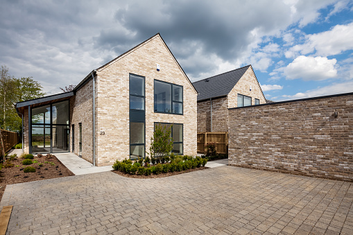 Cambridgeshire, England - May 1 2018: Brand new brick built vacant modern home with block paved drive and landscaped garden