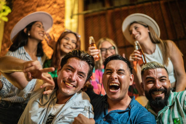 Portrait of friends laughing while talking outdoors at night