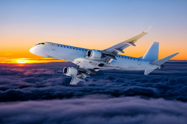 istock White passenger aircraft fly in the sunset sky 1435024639