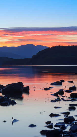 View of sunset over a calm Loch Lomond in The Trossachs, Scotland, UK