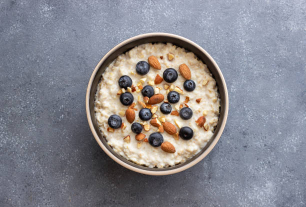 farina d'avena con mirtilli, mandorle e miele. cibo sano. cibo vegetariano. colazione. - oatmeal raisin porridge nut foto e immagini stock