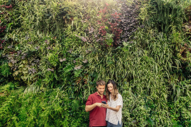 Couple smiling with vertical garden stock photo