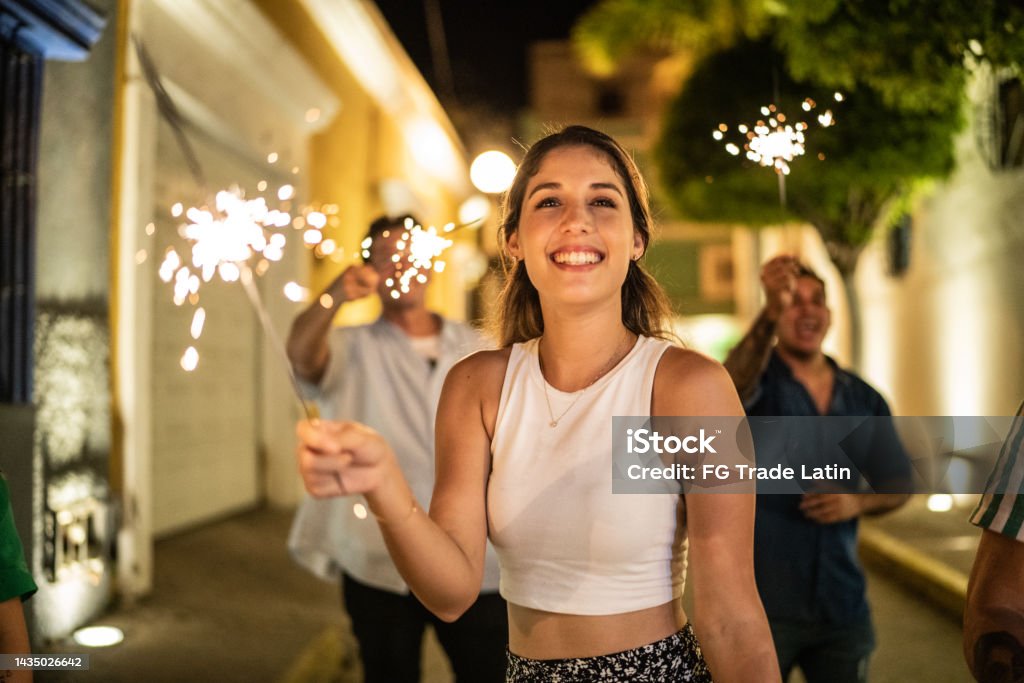 Young woman playing with sparklers on the street at night New Year's Eve Stock Photo
