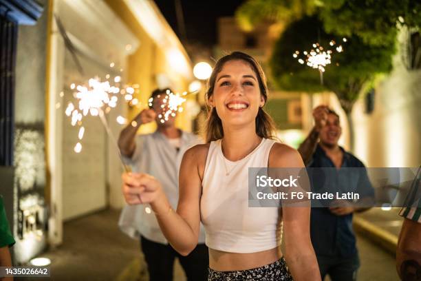 Young Woman Playing With Sparklers On The Street At Night Stock Photo - Download Image Now