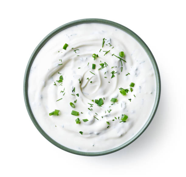Green bowl of sour cream dip sauce with herbs Green bowl of sour cream dip sauce with herbs isolated on white background, top view dipping sauce stock pictures, royalty-free photos & images