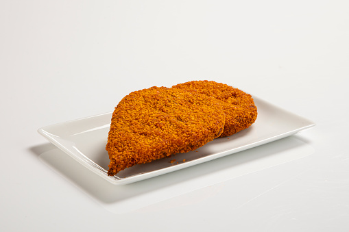 chicken cutlet with herbs on a white plate